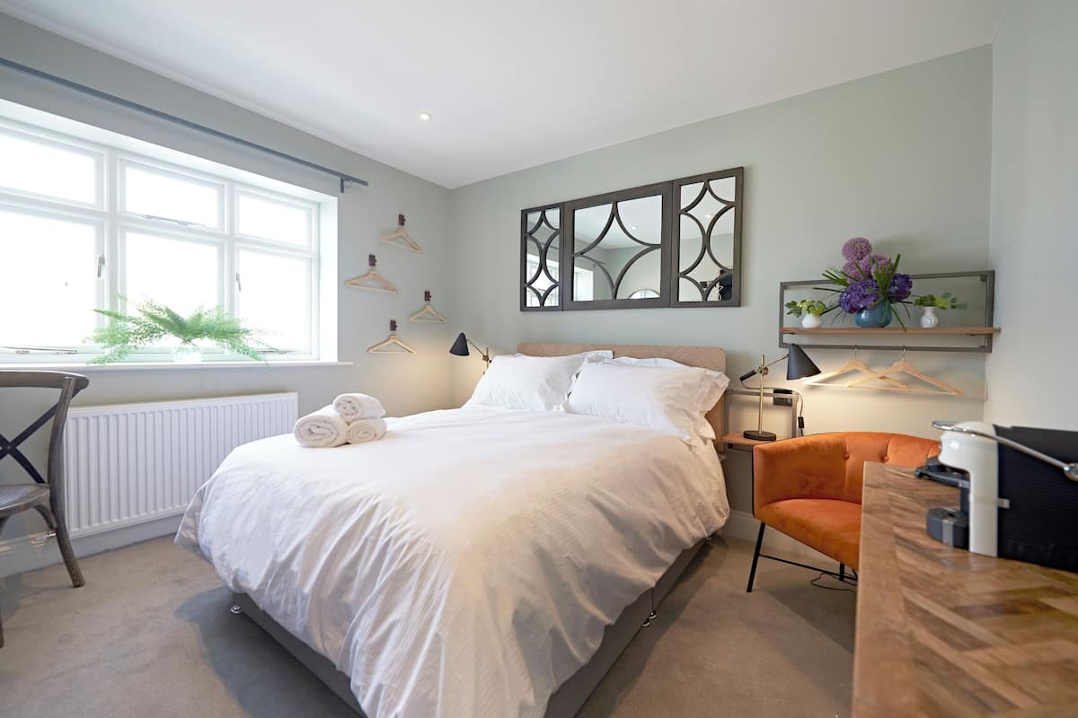 Ein modernes Schlafzimmer mit einem großen Bett, einem Schreibtisch und einem Stuhl.