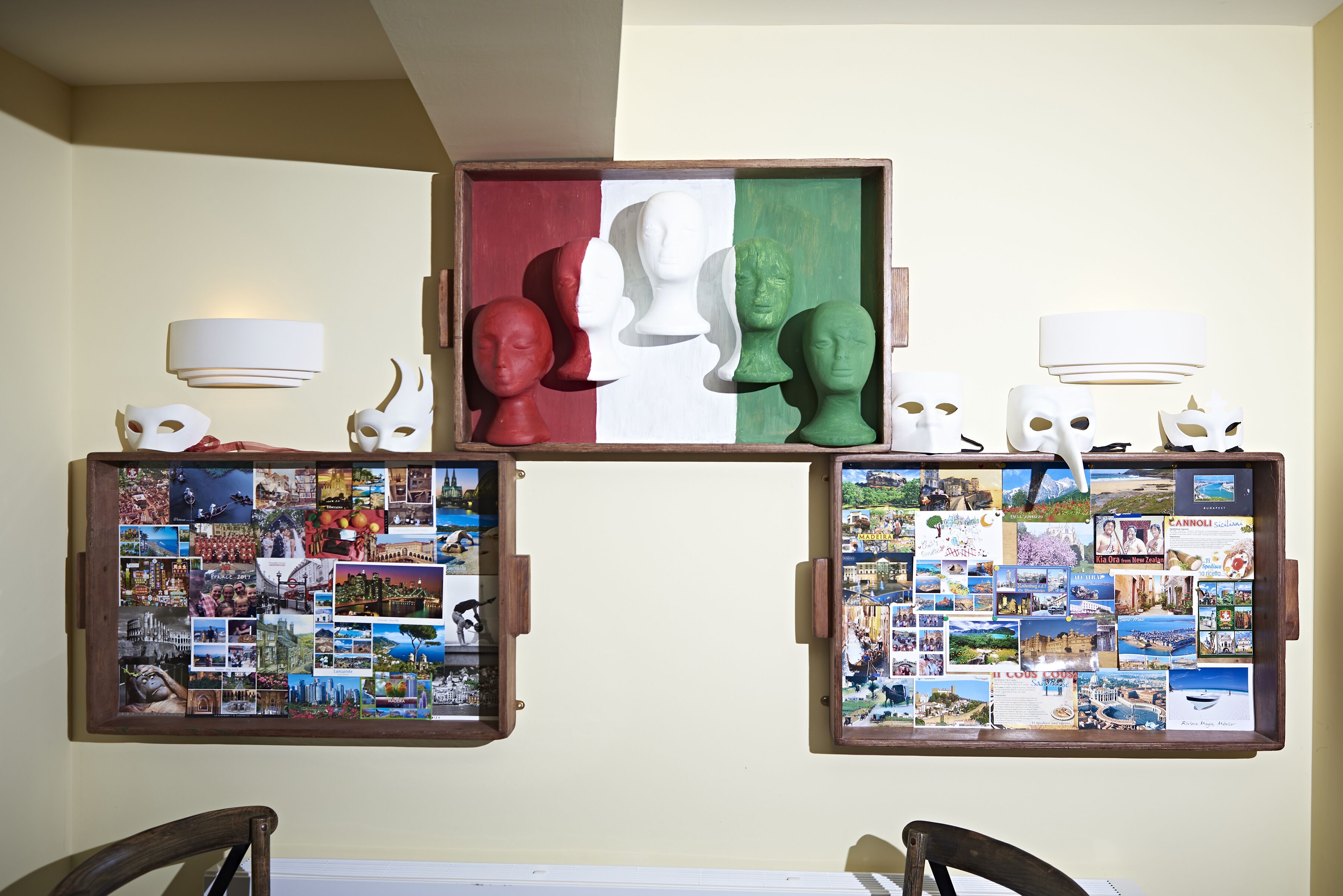 A wall with three framed collages, each with a different background color and various photographs.