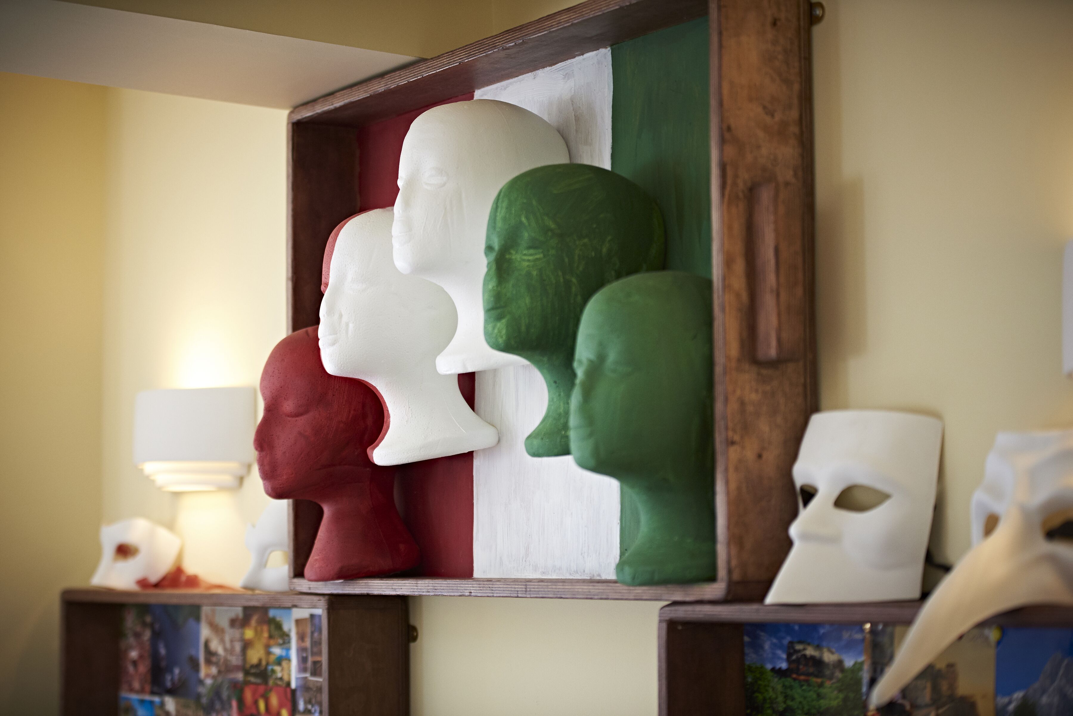 A display of head-shaped sculptures in red, white, and green colors, possibly representing a cultural theme.