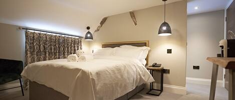 A modern bedroom with a large bed, bedside tables, and a nightstand.