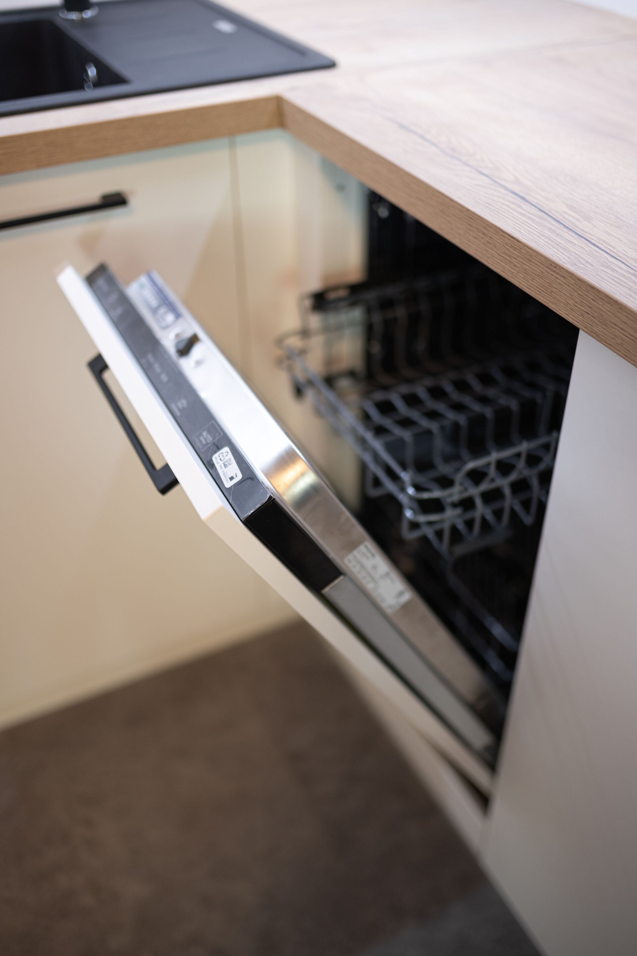 A modern kitchen with a dishwasher integrated into a wooden countertop.