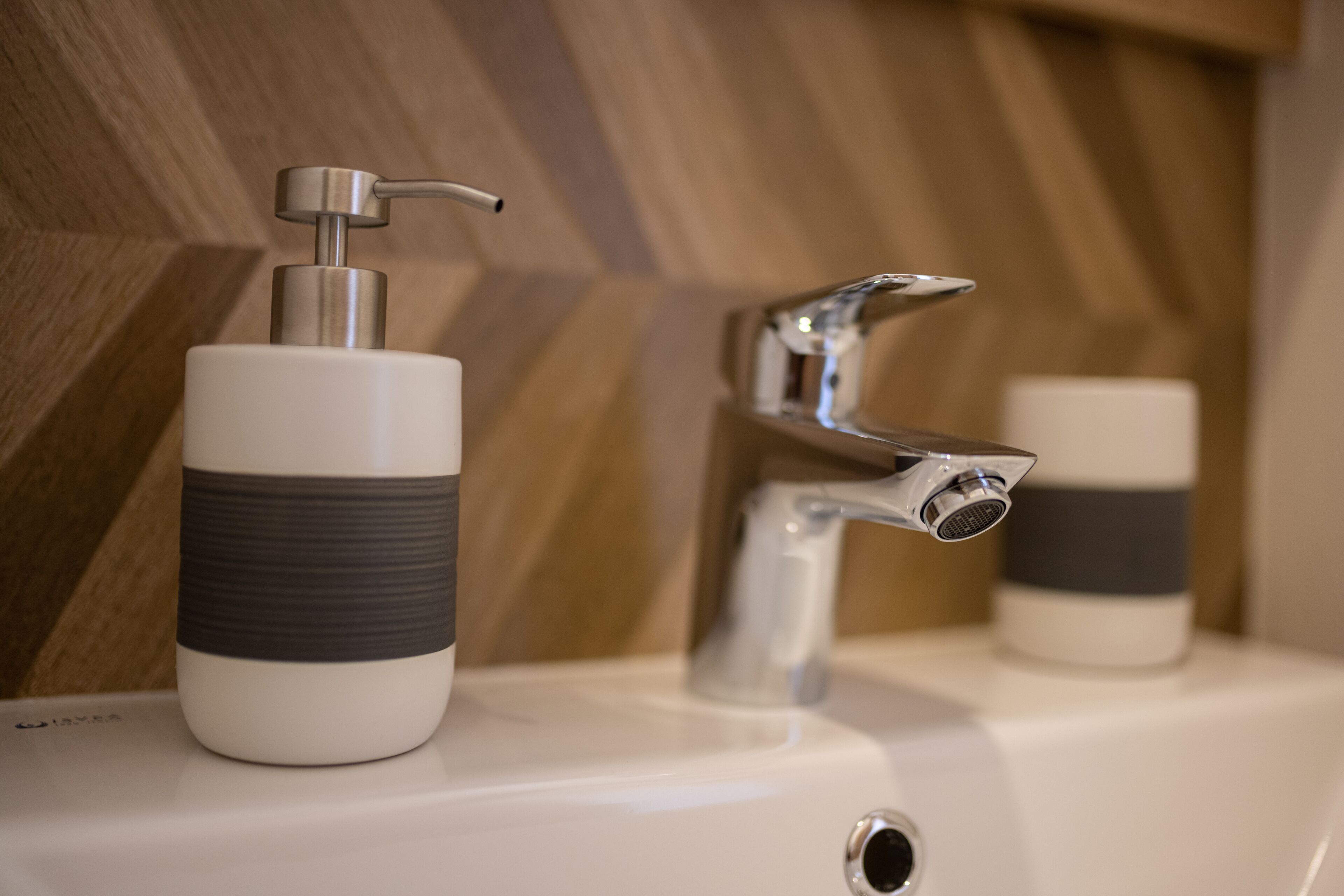 Ein Waschbecken mit modernem Wasserhahn und Seifenspender.