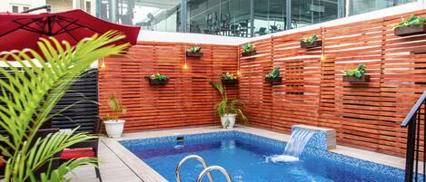 Una piscina al aire libre, sillones reclinables de piscina