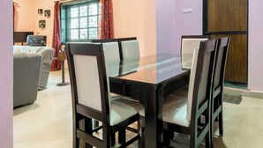 A dining area with a table and chairs, an arched doorway, and a ceiling fan. - Rustic Pvt 2bhk Villa w/ Fiber Net - Dar AlSalaam (Pilar)
