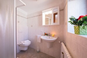 Un baño con inodoro, lavamanos y espejo.
