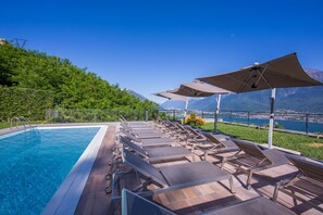 Piscine extérieure, parasols de plage, chaises longues