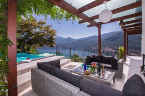 A terrace with outdoor furniture, a swimming pool, and a mountain view. - Villa Acero (Moltrasio)