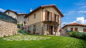 A stone house with a balcony, a paved driveway, and a well-maintained lawn. - Lenno Dolcelago (Tremezzina)
