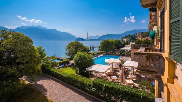 A hotel with a pool, outdoor seating, and a view of the lake and mountains. - Casa Daniele (Menaggio)