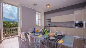 Une cuisine moderne avec un coin repas, de grandes fenêtres et une vue sur la verdure.