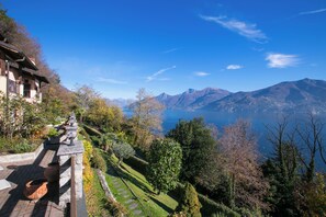 Une vue pittoresque d’une montagne, avec un lac et un bâtiment doté d’un balcon offrant une vue panoramique sur le paysage.