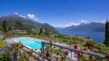 Een buitenzwembad, ligstoelen bij het zwembad