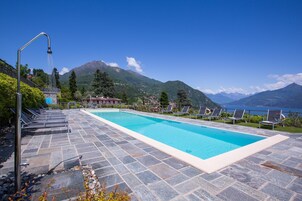 Una piscina al aire libre, sillones reclinables de piscina