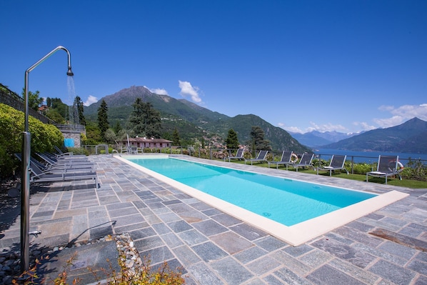 Una piscina al aire libre, sillones reclinables de piscina
