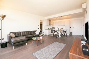 Ein modernes Wohnzimmer mit Sofa, Couchtisch und TV-Schrank.