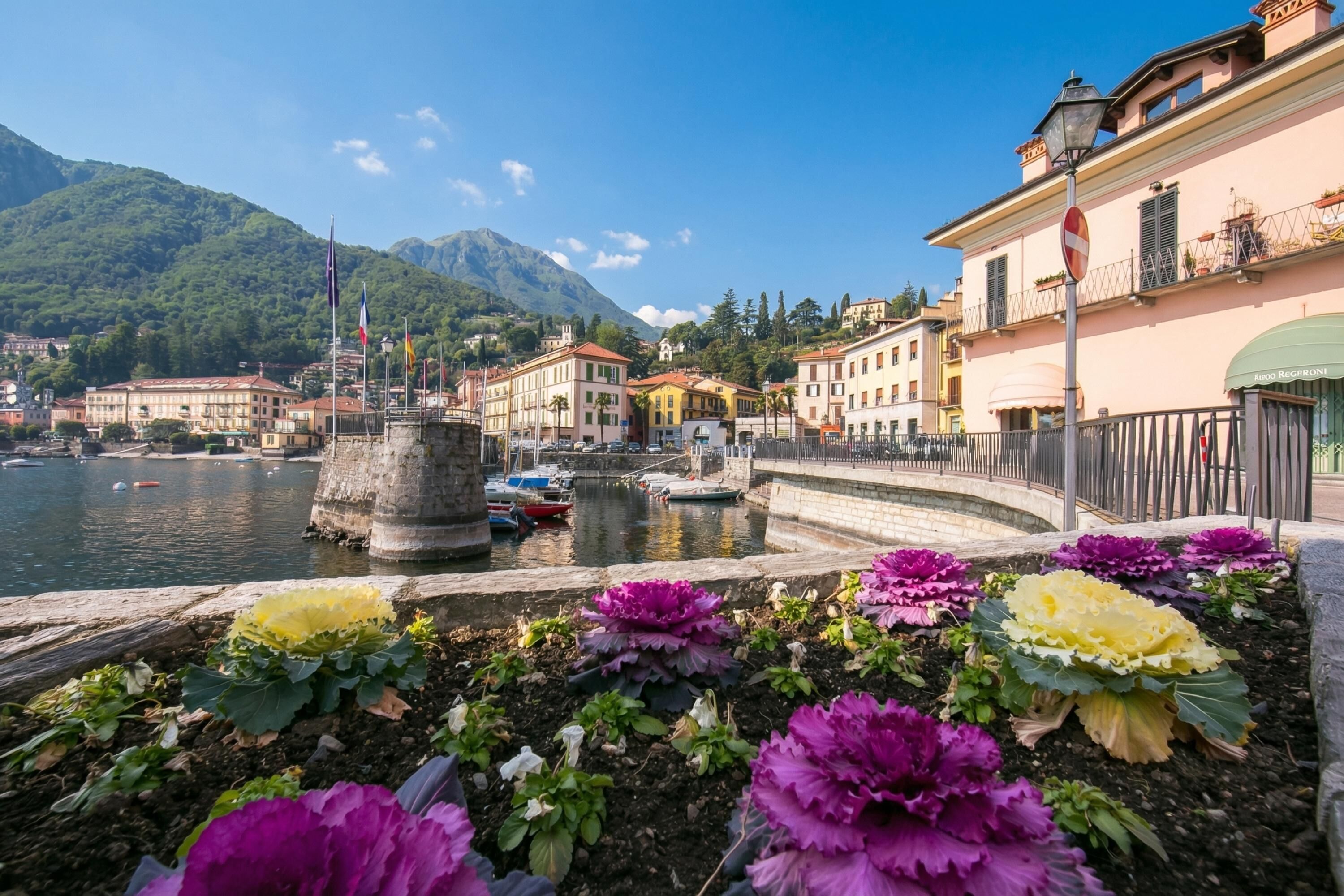 A waterfront view with buildings, a stone structure, and colorful flowers.