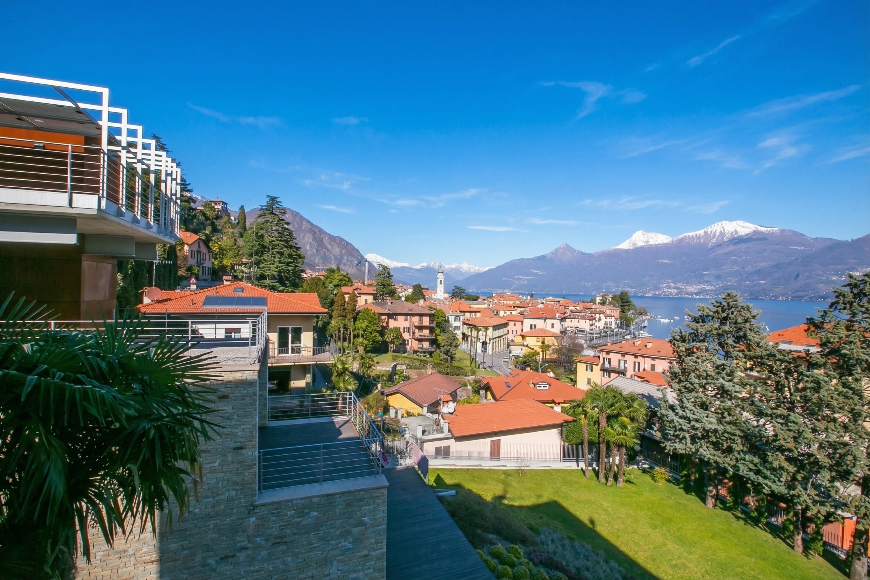 A hillside residential area with a view of a mountain and lake.
