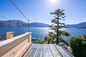 A balcony with a view of a lake, mountains, and a clear sky. - Villa Evelyn Terrazzo (Menaggio)