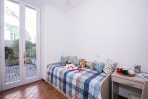 Un dormitorio con cama, escritorio y vistas a través de un ventanal.