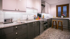 Una cocina moderna con armarios grises oscuros, encimera de granito, horno empotrado y ventana con vistas.