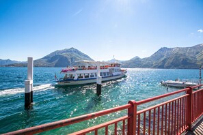 A boat on a lake with mountains in the background. - Casa Al Prato Apt. B (Varenna)
