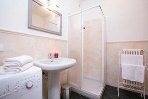 A bathroom with a sink, mirror, shower, and towel rack. - Casa Al Prato Apt. G (Varenna)