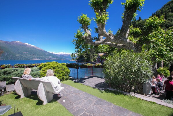 A stone bench with a view of a lake and mountains.