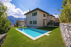 Una piscina al aire libre, sillones reclinables de piscina