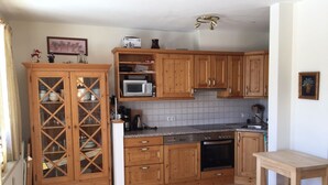 A kitchen with wooden cabinets, a microwave, a stove, and a sink.