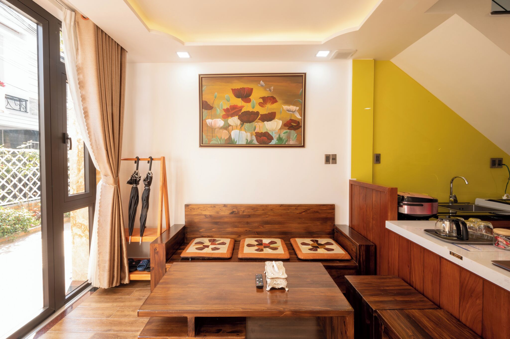Una cocina moderna con armarios de madera, una mesa de comedor y un cuadro grande en la pared.
