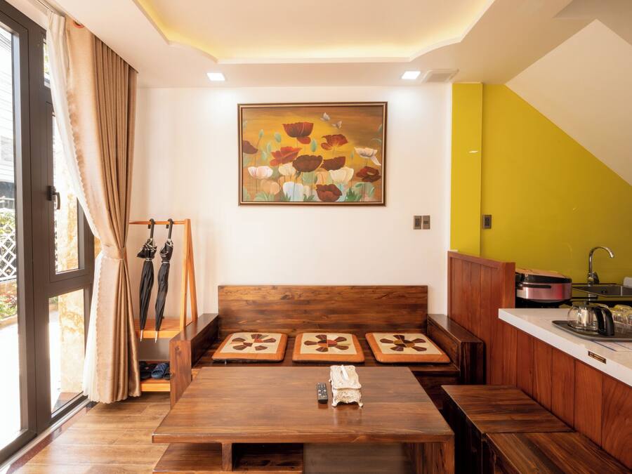 Una cocina moderna con armarios de madera, una mesa de comedor y un cuadro grande en la pared.