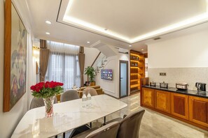 Una cocina moderna con armarios de madera, encimera de mármol y horno empotrado.