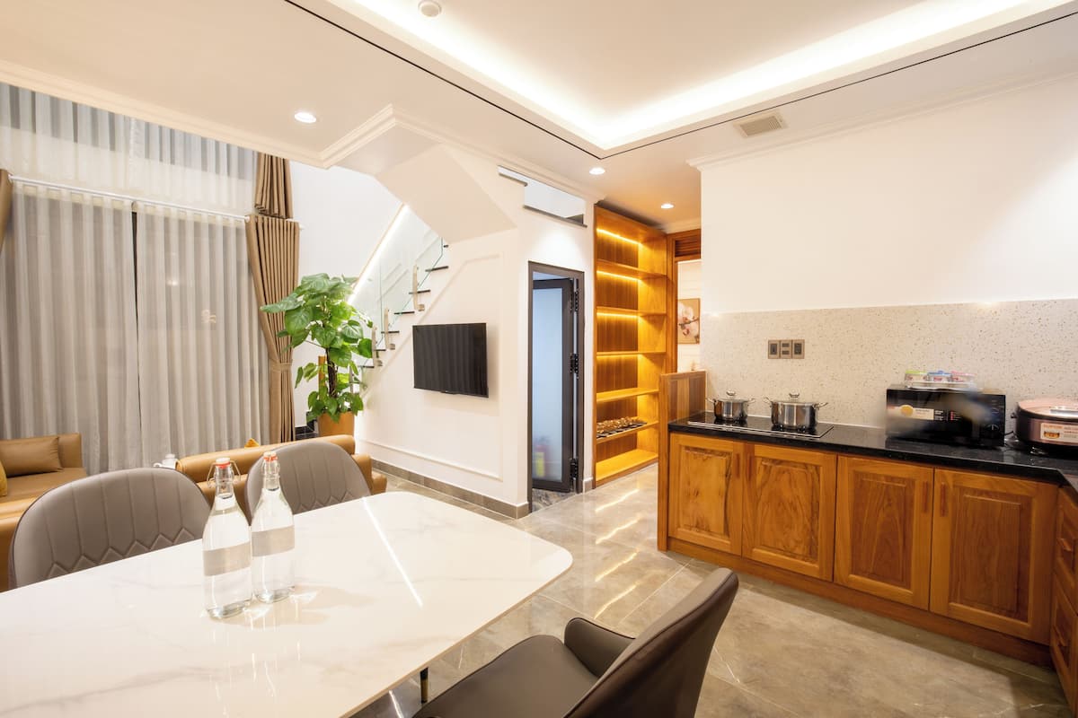 A modern kitchen with wooden cabinets, a marble countertop, and a built-in oven.