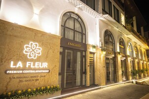 Ein Hotelgebäude mit der Aufschrift 'LA FLEUR PREMIUM CENTRAL APARTMENT' und Kontaktinformationen.