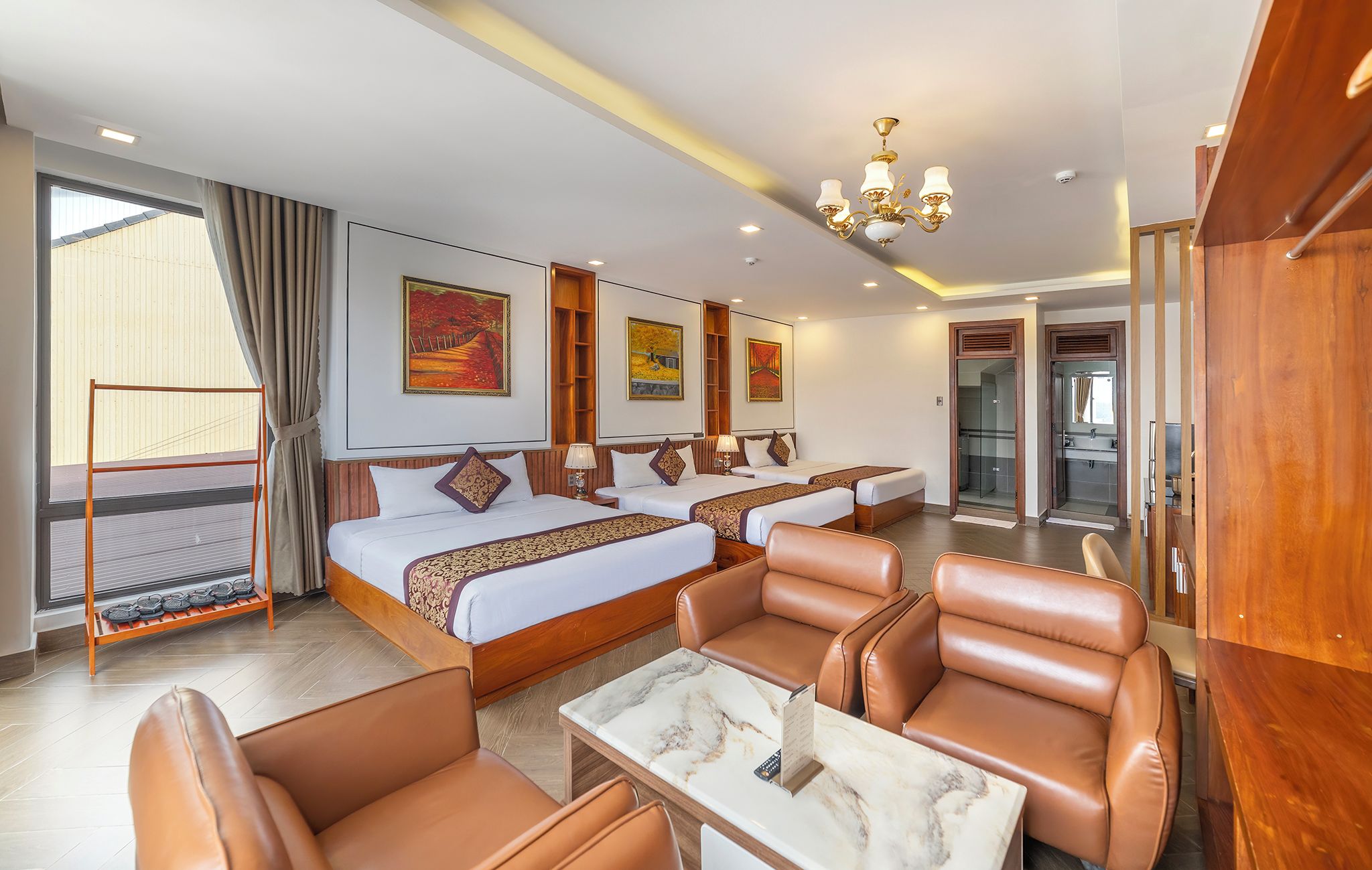Ein Hotelzimmer mit einem Bett, zwei Nachttischen, einer Sitzecke mit Stühlen, einem kleinen Tisch und einem Duschbereich.