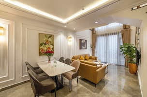 A modern living room with a dining area, featuring a sofa set, a coffee table, and a dining table with chairs.