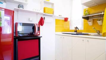 Fridge, microwave, coffee/tea maker, cookware/dishes/utensils