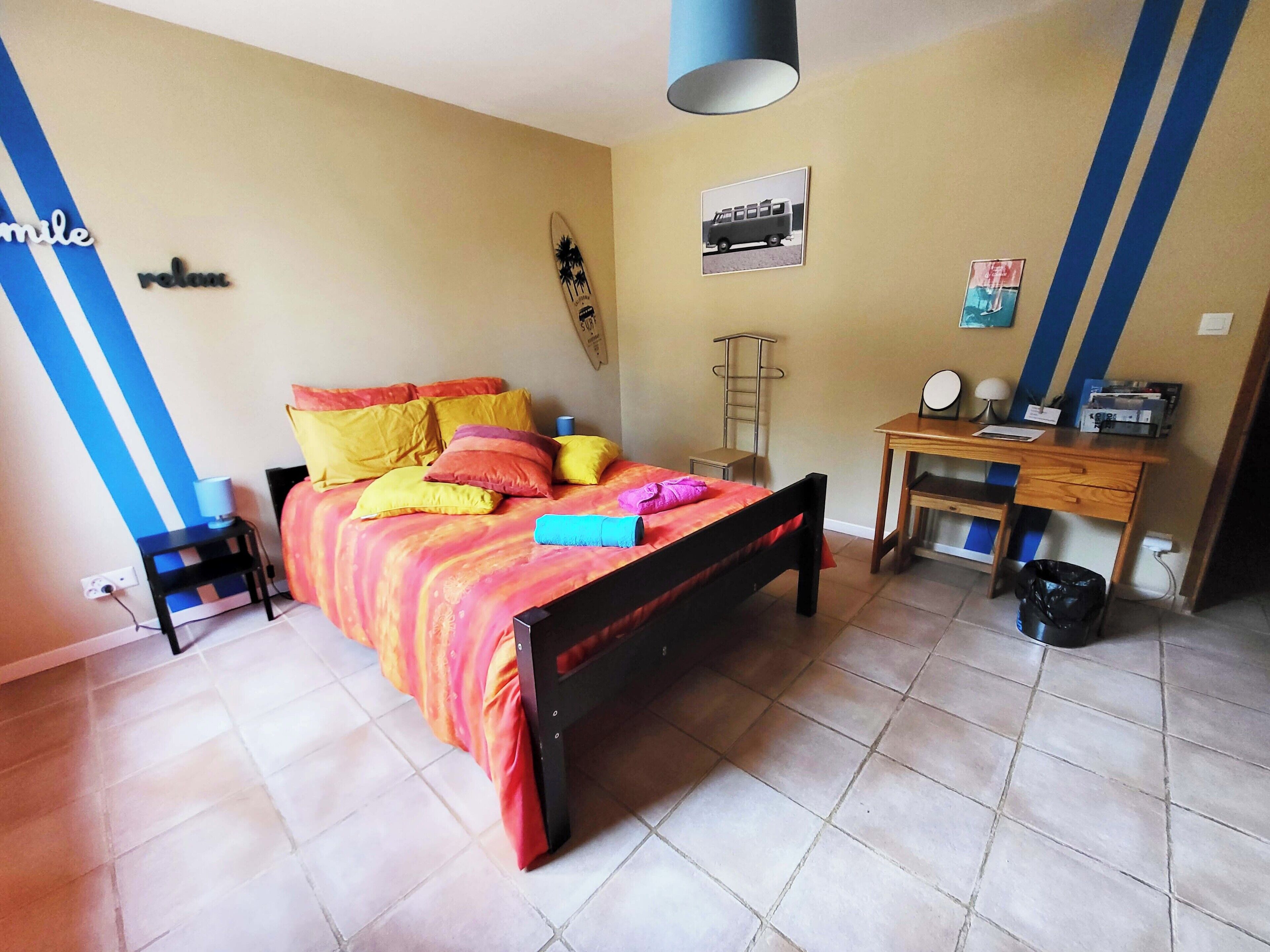 Un dormitorio con cama, escritorio y silla.