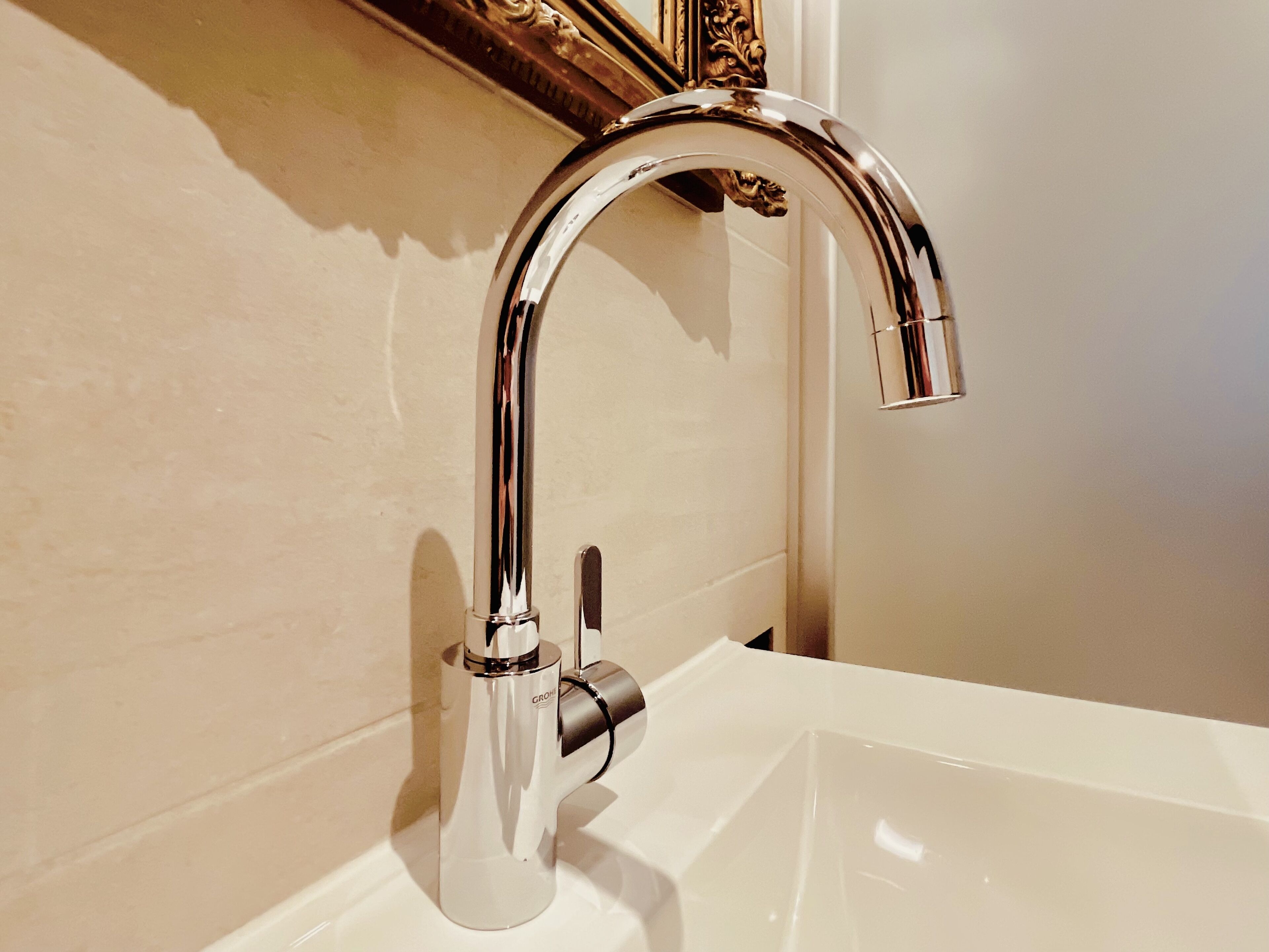 Une salle de bain moderne avec un robinet chromé et un lavabo blanc.