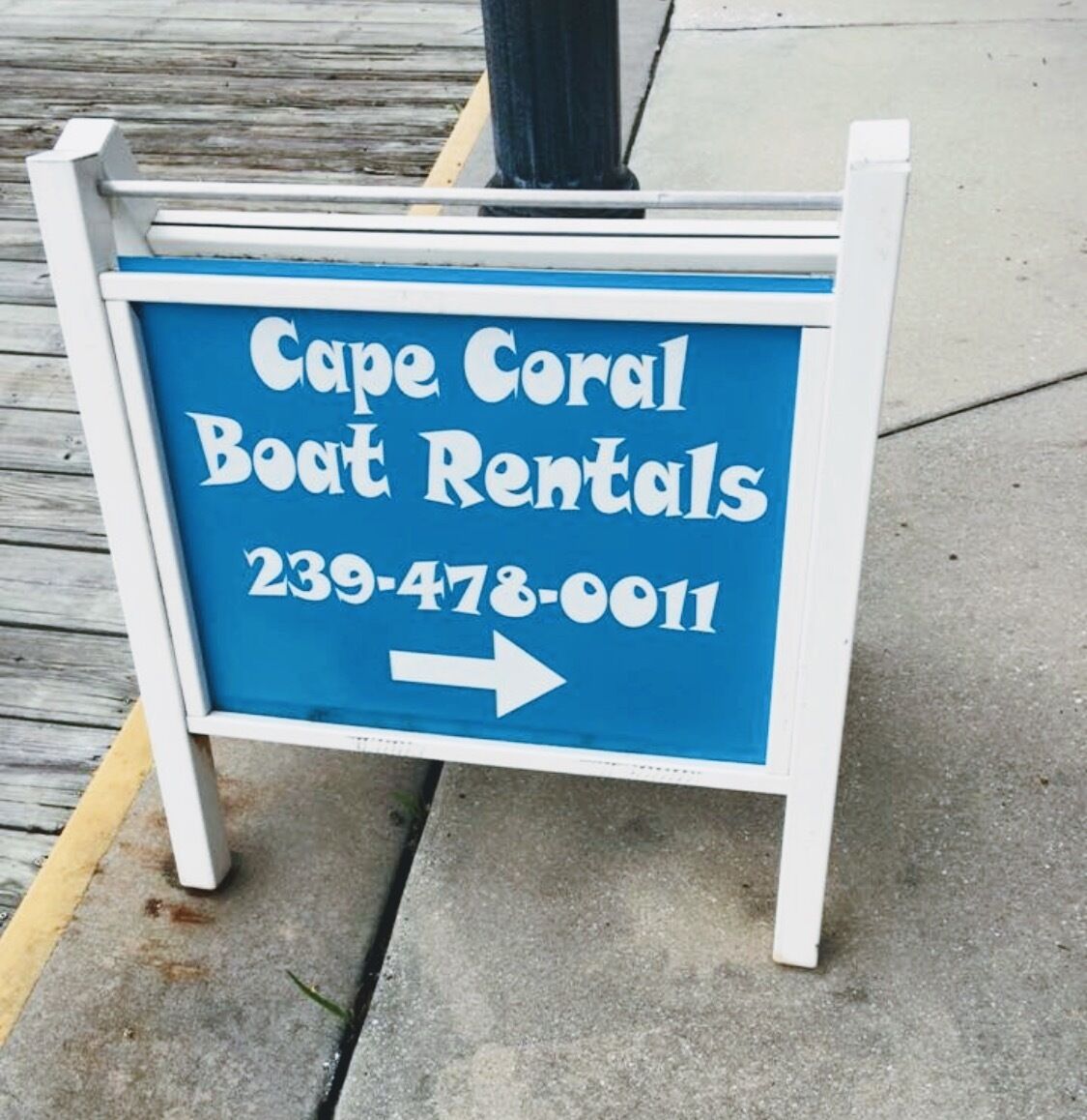 A sign for Cape Coral Boat Rentals with a contact number.