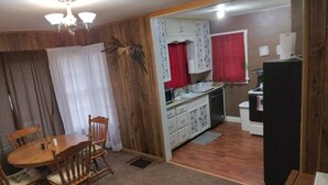 A compact kitchen with wooden cabinets, a microwave, and a refrigerator.