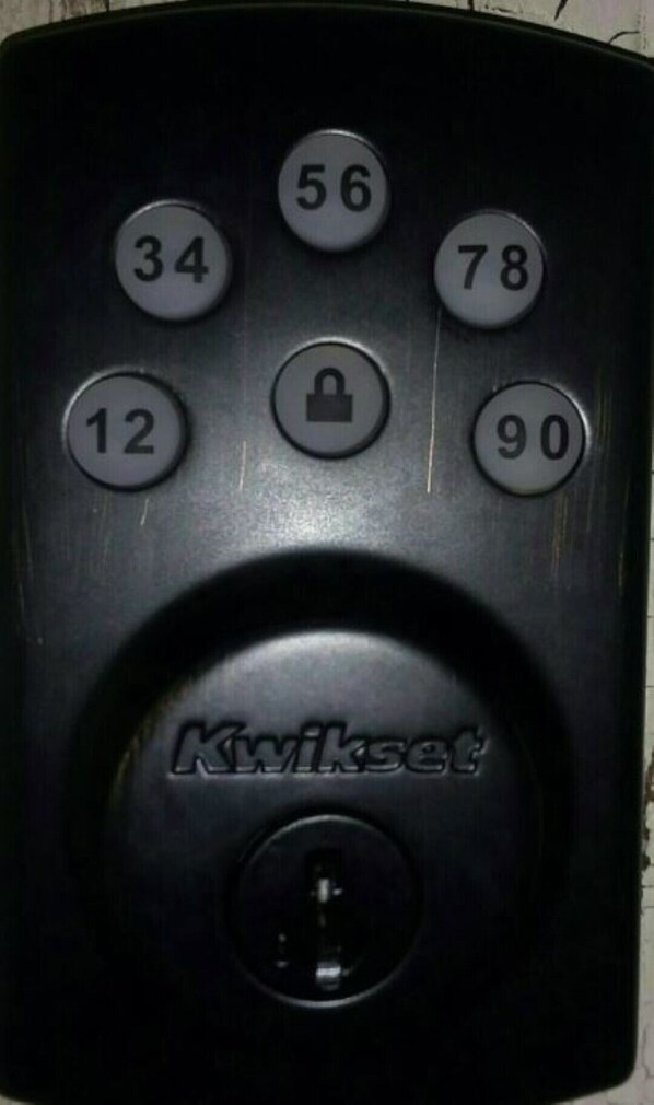 A black remote control with numbered buttons and a lock symbol.