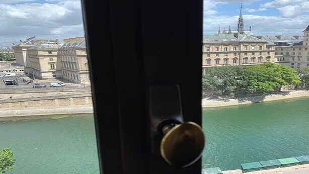 Blick auf einen Fluss mit Gebäuden im Hintergrund.