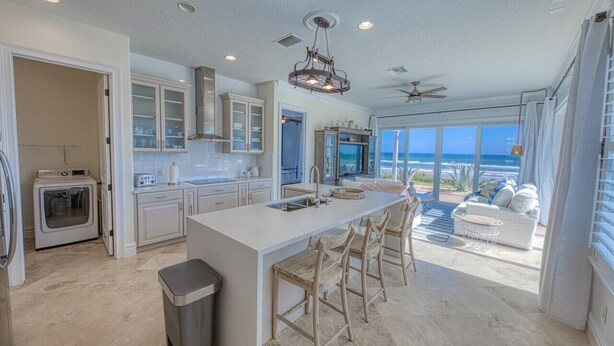 A spacious kitchen with a large island, modern appliances, and a view of the ocean.