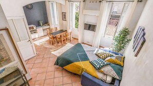 Una habitación amplia con cama, una mesa de comedor, sillas y una zona de cocina.