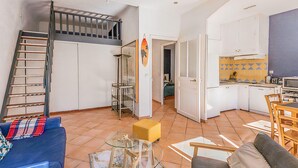 Un espacio habitable compacto con dormitorio en entrepiso, kitchenette y comedor.