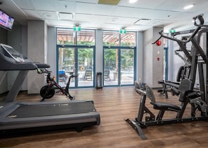 Ein Fitnessraum mit Laufband, Ergometer und Krafttrainingsgeräten.