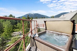 Ein Whirlpool auf einem Balkon mit Blick auf die Berge.