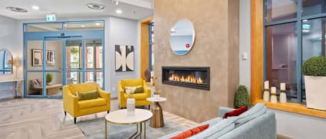 A modern lobby with a fireplace, seating area, and a large window.