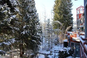 A snow-covered landscape with trees and a building with a red facade.